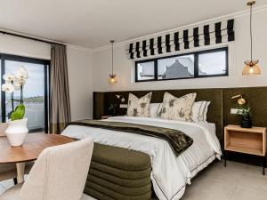 普利登堡湾Plettenvale Wines的一间卧室，里面有一张大床和一张桌子。