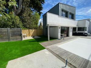 a house with a green lawn in front of it at Mimosette Villa pool & jacuzzi 4 bedrooms in Le Pouliguen