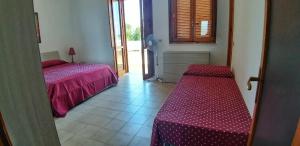 a room with two beds and a table in it at La Dimora di Patty in San Cataldo