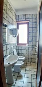 a bathroom with two toilets and a sink and a window at La Dimora di Patty in San Cataldo +5 photos