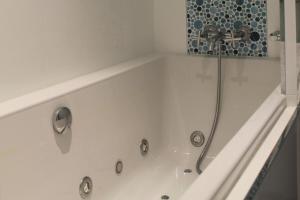 a white bath tub with a faucet in a bathroom at Mimosette Villa pool & jacuzzi 4 bedrooms in Le Pouliguen +14 photos