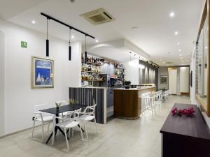 un ristorante con bar, tavoli e sedie di Best Western Hotel Martello a Lampedusa