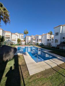 a swimming pool in front of some apartment buildings at Laguna Beach 15 Primera linea de Playa in Morche