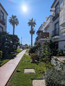 a walkway between two buildings with palm trees at Laguna Beach 15 Primera linea de Playa in Morche +4 photos