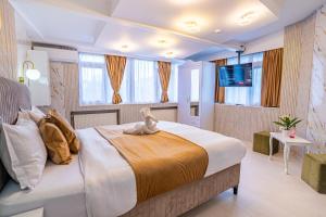 Iancu Jianu Premium Stay Apartment في بوخارست: غرفة نوم بسرير كبير عليها دبدوب