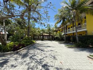 a driveway in front of a building with palm trees at Hotel Mar de Cabo Frio in Cabo Frio
