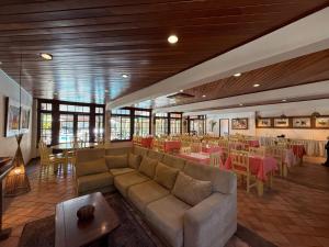 a restaurant with a couch and tables and chairs at Hotel Mar de Cabo Frio in Cabo Frio