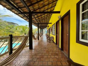 a yellow building with a hammock on a walkway at Hotel Mar de Cabo Frio in Cabo Frio +20 photos