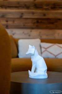 een wit beeldje van een hond die op een tafel zit bij Chalet Azureva Le Bettaix in Levassaix