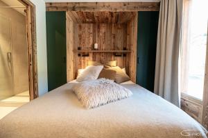 een slaapkamer met een groot bed met groene muren bij Chalet Azureva Le Bettaix in Levassaix