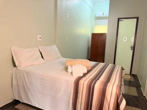 a bedroom with a bed with two towels on it at Hotel Coutinho PIO XII in Pirapora
