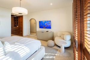 a bedroom with a white bed and a chair at Ocean view Escape Private Plunge Pool Concierge in Punta Mita