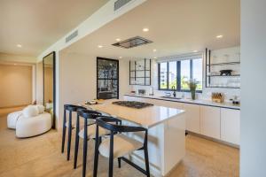 a kitchen with a large island with stools at Ocean view Escape Private Plunge Pool Concierge in Punta Mita