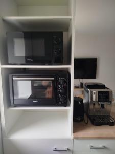 a kitchen with a microwave oven and a printer at Appartement cocooning in Laval