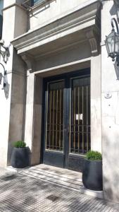 een voordeur van een gebouw met twee potplanten bij Departamento Centro BA in Buenos Aires