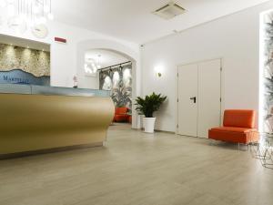 un atrio d'ufficio con una sedia arancione e un bancone di Best Western Hotel Martello a Lampedusa