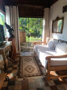 una camera da letto con un letto e una grande finestra di casa com riacho cristalino,lago,hidro,bela vista a Santo Antônio do Pinhal