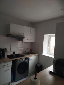 a kitchen with a sink and a washing machine at Appartement cocooning in Laval