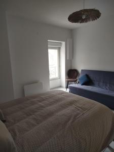 a bedroom with a bed and a couch and a window at Appartement cocooning in Laval