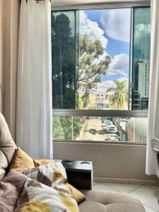 a bedroom with a window with a view of a street at Apartamento completo no centro da cidade in Passo Fundo