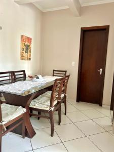 a dining room with a table and chairs and a door at Apartamento completo no centro da cidade in Passo Fundo +3 photos