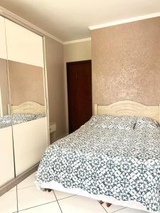 a bedroom with a bed and a glass door at Apartamento completo no centro da cidade in Passo Fundo