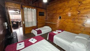 two beds in a room with wooden walls at Pousada Canto da Montanha in Guarujá +85 photos