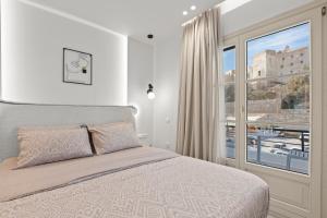 a bedroom with a bed and a large window at Pnoe Luxe Apartment & Spa, Naxos Town in Naxos Chora