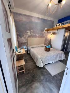 Camera di Zio Peppe- Vintage Room في سانتا تيريزا غالّورا: غرفة نوم صغيرة مع سرير وطاولة +4 صور