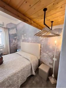 Camera di Zio Peppe- Vintage Room في سانتا تيريزا غالّورا: غرفة نوم بها سرير وسقف خشبي