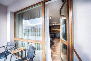 a balcony with chairs and a table and a glass door at Best Central LUX Studio in Bansko