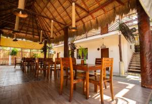 uma sala de jantar com mesas e cadeiras de madeira em Hotel Boutique Bahia Azul em Bacalar