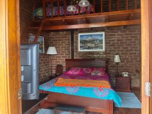 una camera da letto con un letto in un muro di mattoni di La Rustica Hotel a Guaranda