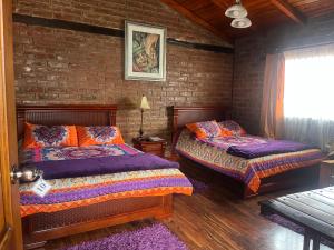 una camera da letto con due letti e un muro di mattoni di La Rustica Hotel a Guaranda