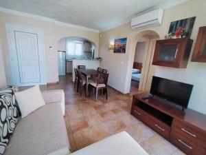 een woonkamer met een bank, een tv en een tafel bij Met y playa in Casas Devesa