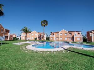 een zwembad in een tuin met huizen bij Met y playa in Casas Devesa
