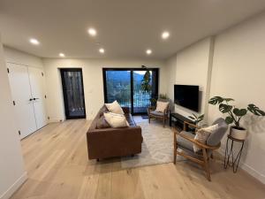 een woonkamer met een bank en een televisie bij 2BR, Views, Spacious, Luxury, New Home in Whistler