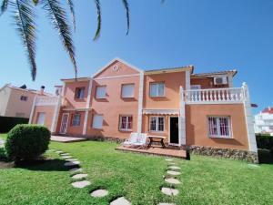 een huis met een palmboom en een gazon bij Met y playa in Casas Devesa