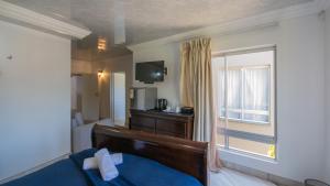 マーゲートにあるFalling Waters Guest Houseのベッドと窓のあるホテルの部屋