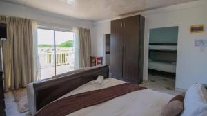 マーゲートにあるFalling Waters Guest Houseのベッドとバルコニーのある寝室 +68枚の写真