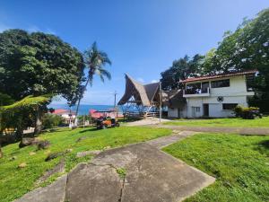 a house with a grassy yard next to a building at Hotel San Pedro de Taboga in Taboga