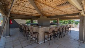 マーゲートにあるFalling Waters Guest Houseの木製の天井のあるパティオにあるスツール付きのバー