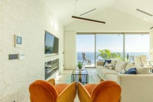 ein Wohnzimmer mit Sofa und Tisch in der Unterkunft Villa CLIFF HEAVEN HOUSE in Calheta