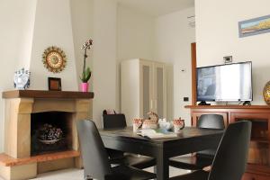 Lunigiana - Casa Anita Con Giardino في كاستيلنوفو ماغرا: غرفة طعام مع طاولة وتلفزيون