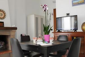 Lunigiana - Casa Anita Con Giardino في كاستيلنوفو ماغرا: طاولة طعام مع كراسي وتلفزيون