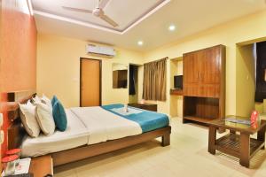 巴罗达Hotel O Sunrise的一间卧室，里面有一张大床和一张桌子。