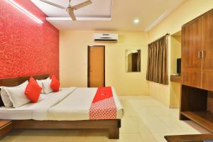 巴罗达Hotel O Sunrise的一间带床和红墙的卧室 更多79张照片