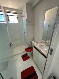 um banheiro com vaso sanitário, pia e chuveiro em Melhores Flats - Tranquilo, pertinho do mar em João Pessoa