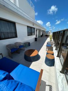 um pátio com mesas e cadeiras em um prédio em Melhores Flats - Tranquilo, pertinho do mar em João Pessoa mais 25 fotografias