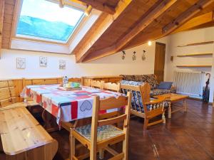 ジアーノ・ディ・フィエンメにあるAttico Lagorai - Alpine Stay Apartmentsのテーブルと椅子と窓のあるリビングルーム